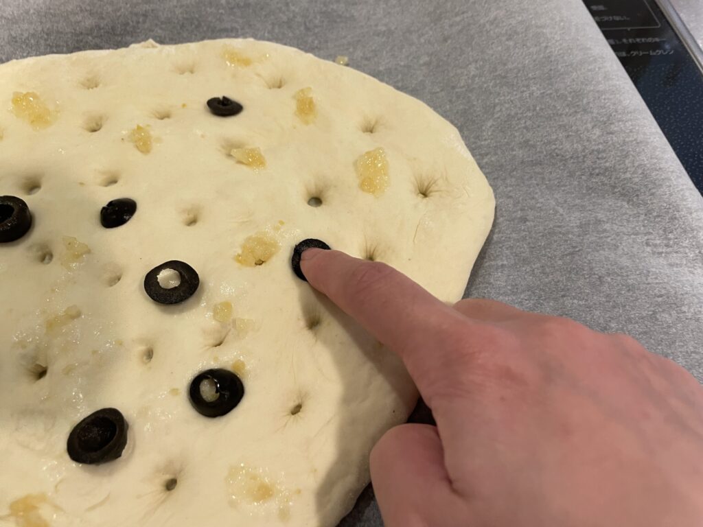 フォカッチャ生地にオリーブをトッピングしているところ
